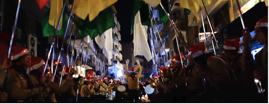 Christmas opening ceremony with a marching band and festive decorations.